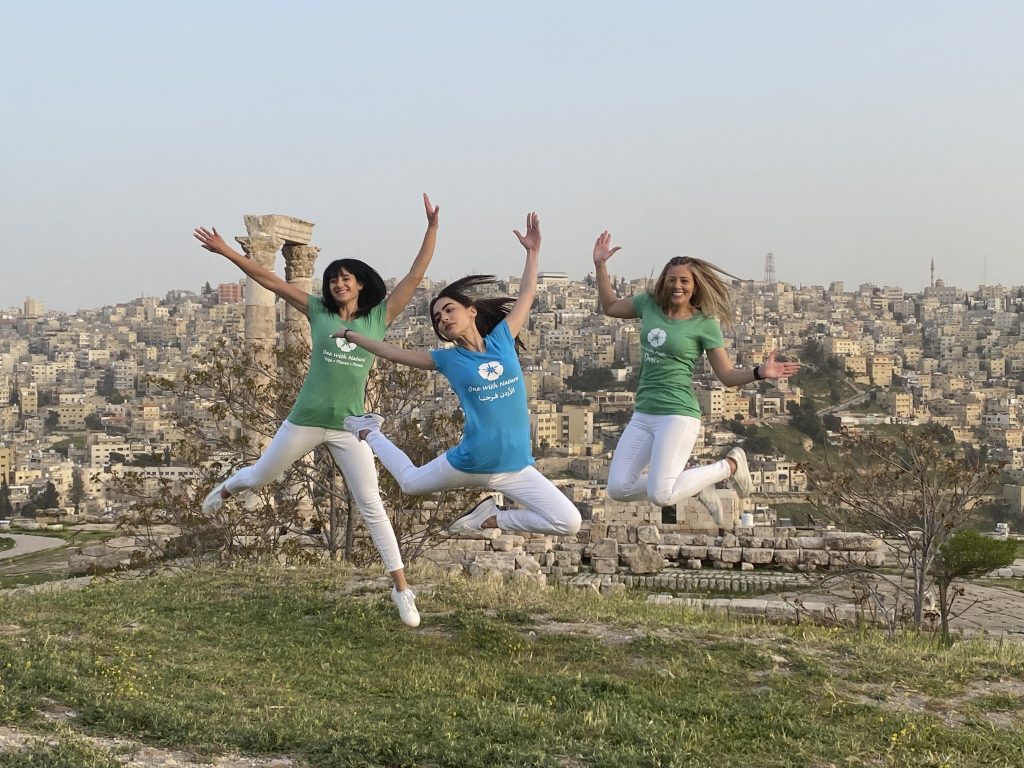 Women jumping outdoors overlooking Amman