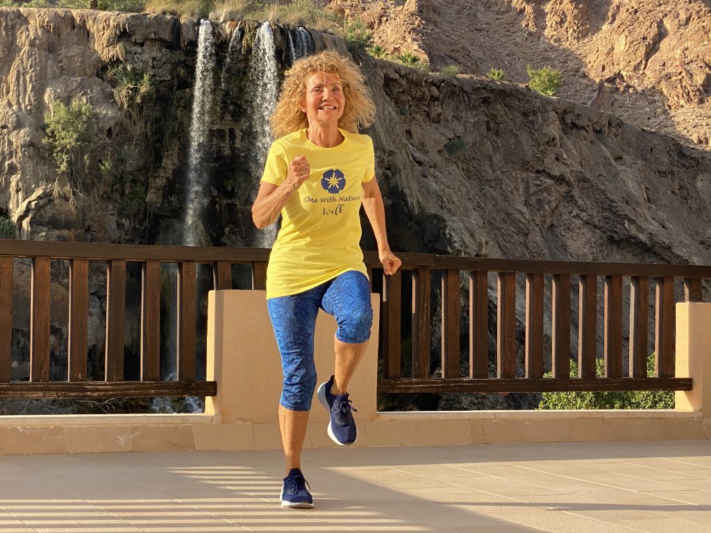 Woman walking outdoors near a waterfall